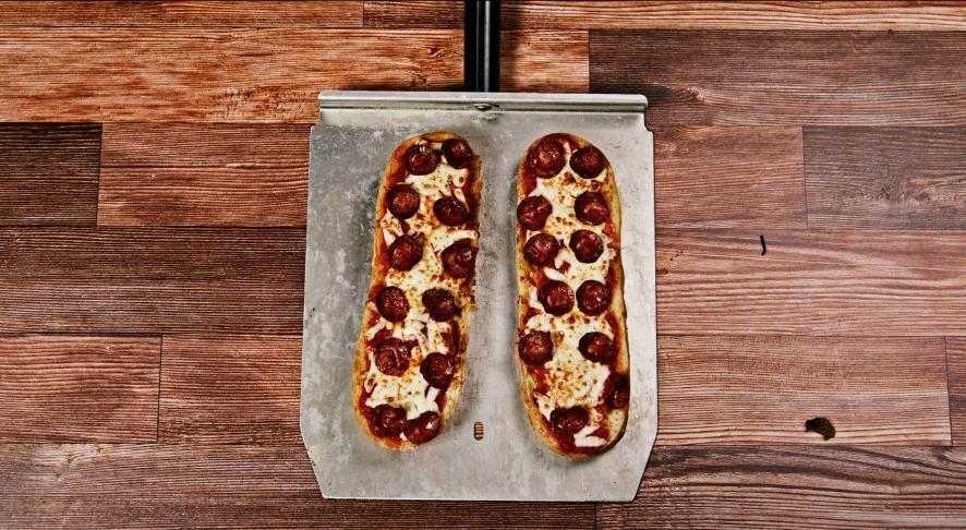 Freshly baked pepperoni pizza on wooden board